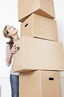 Woman Carrying Stack Of Cardboard Boxes Looking Up Fmkf Jo Kirchherr Westend61