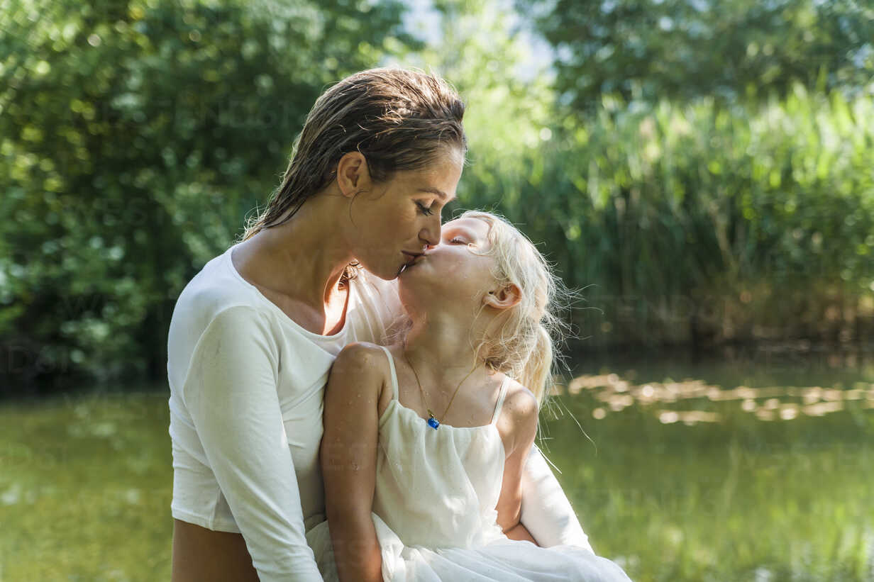 Mother and daughter cuddling at a lake — nature, Sensory 