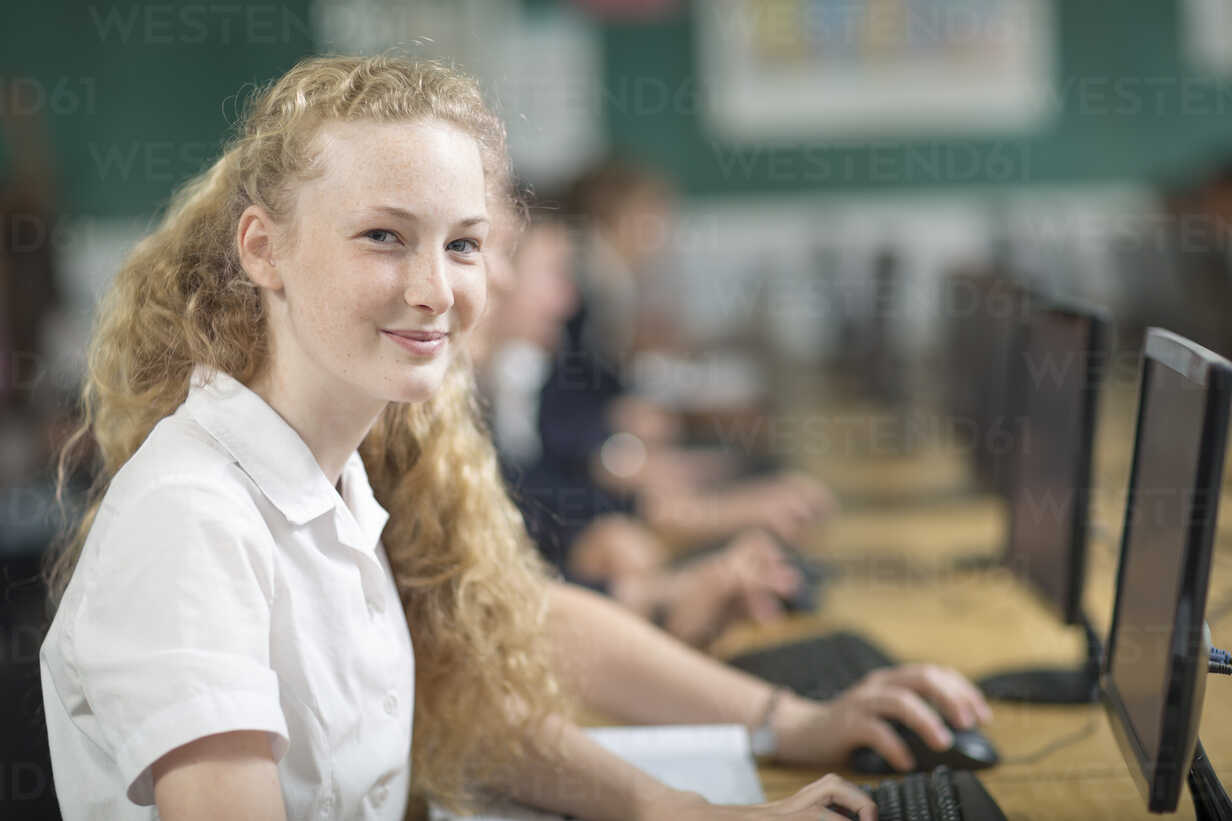 Portrait Of Smiling High School Student At Desk With Computer