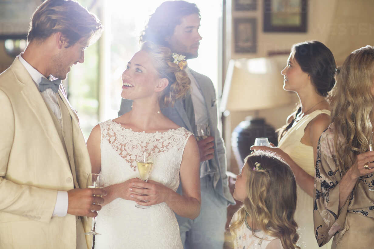 Young Couple With Guests And Champagne Flutes At Wedding Reception Stockphoto