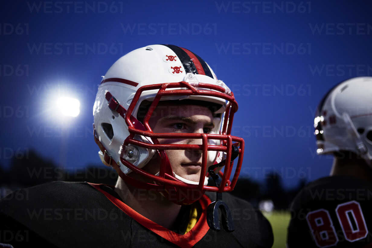Close Up Of Teenage American Football Player Against Sky At Dusk Stockphoto