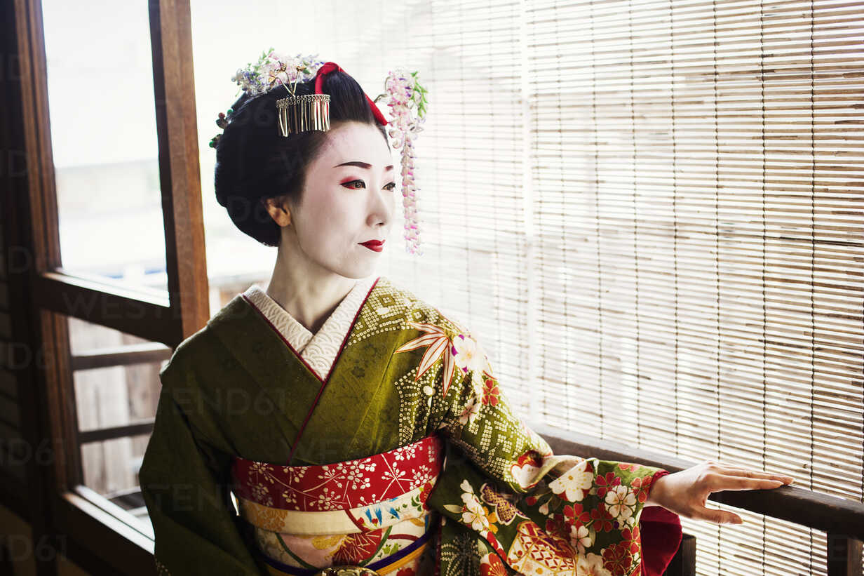 A Woman Dressed In The Traditional Geisha Style Wearing A Kimono And Obi With An Elaborate