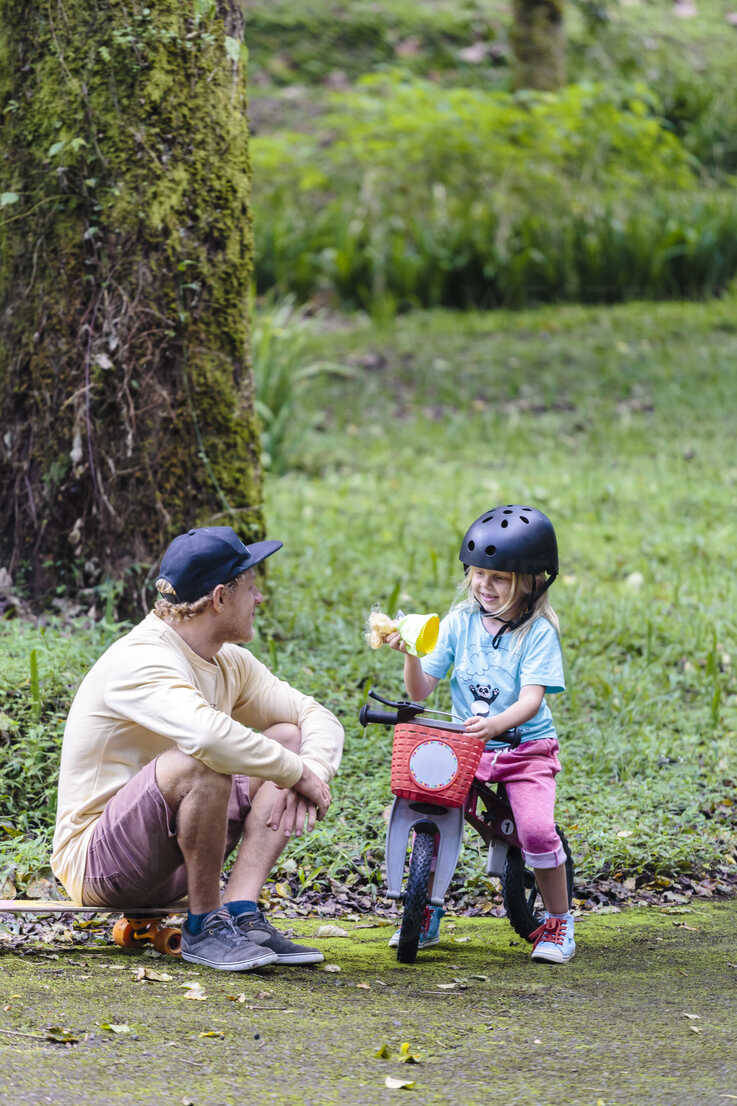 Father And Daughter With Bike In Park Bedugul Bali Indonesia Aurf06868 Cavan Images Westend61