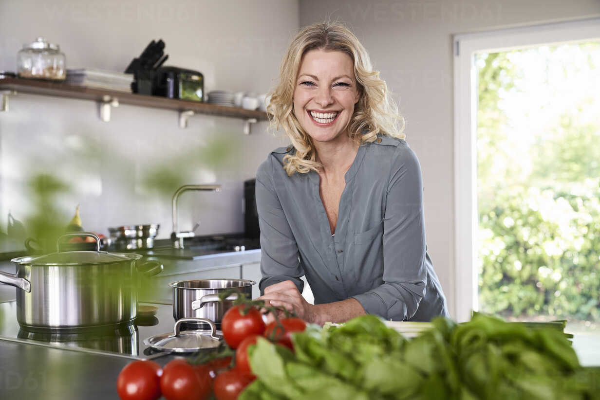 https://images1.westend61.de/0001046660pw/portrait-of-happy-woman-cooking-in-kitchen-PDF01730.jpg