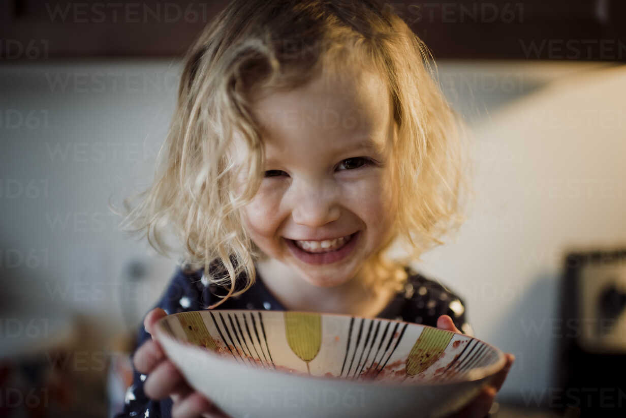 Close Up Portrait Of Happy Girl Holding Bowl At Home Cavf Cavan Images Westend61