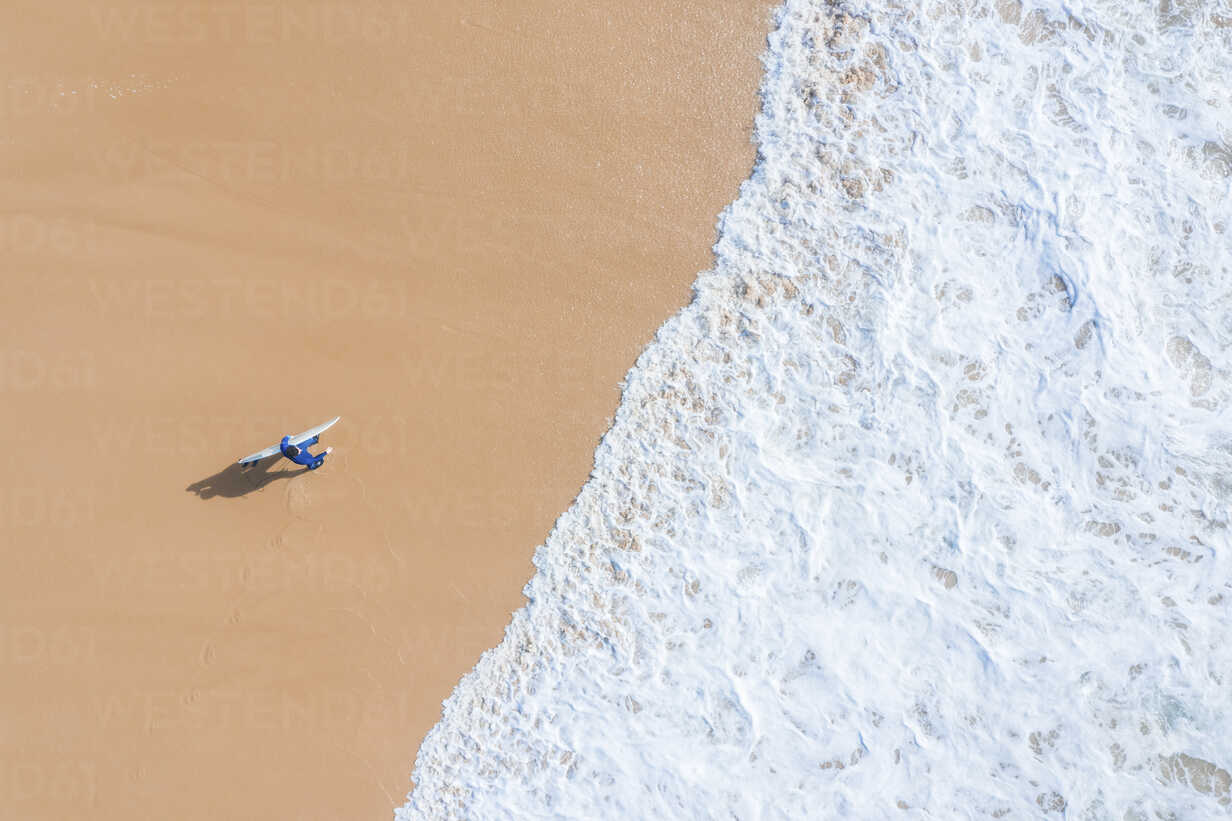 Portugal Algarve Sagres Praia Da Mareta Aerial View Of Man Carrying Surfboard On The Beach Mmaf