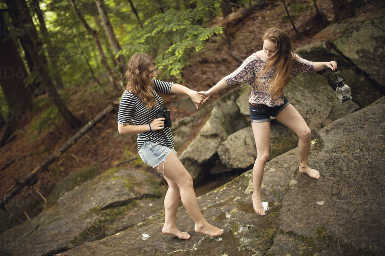 Girls Walking Barefoot On Boulder In Forest Stockphoto