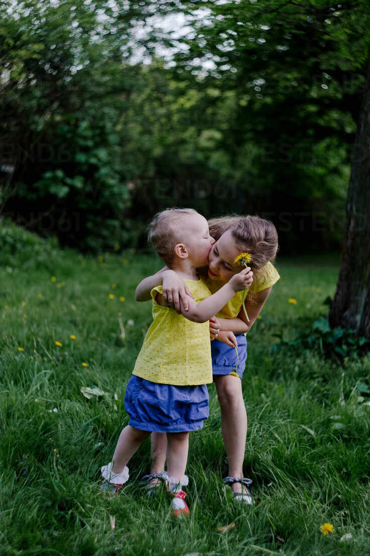 Little Girl Kissing Her Sister On A Meadow Ogf Oxana Guryanova Westend61