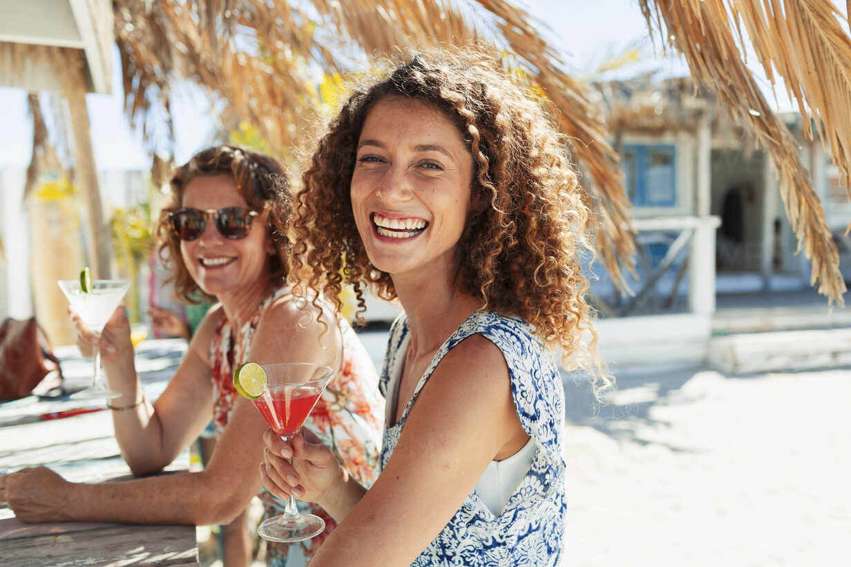 Portrait Happy Women Drinking Cocktails At Sunny Beach Bar Stockphoto