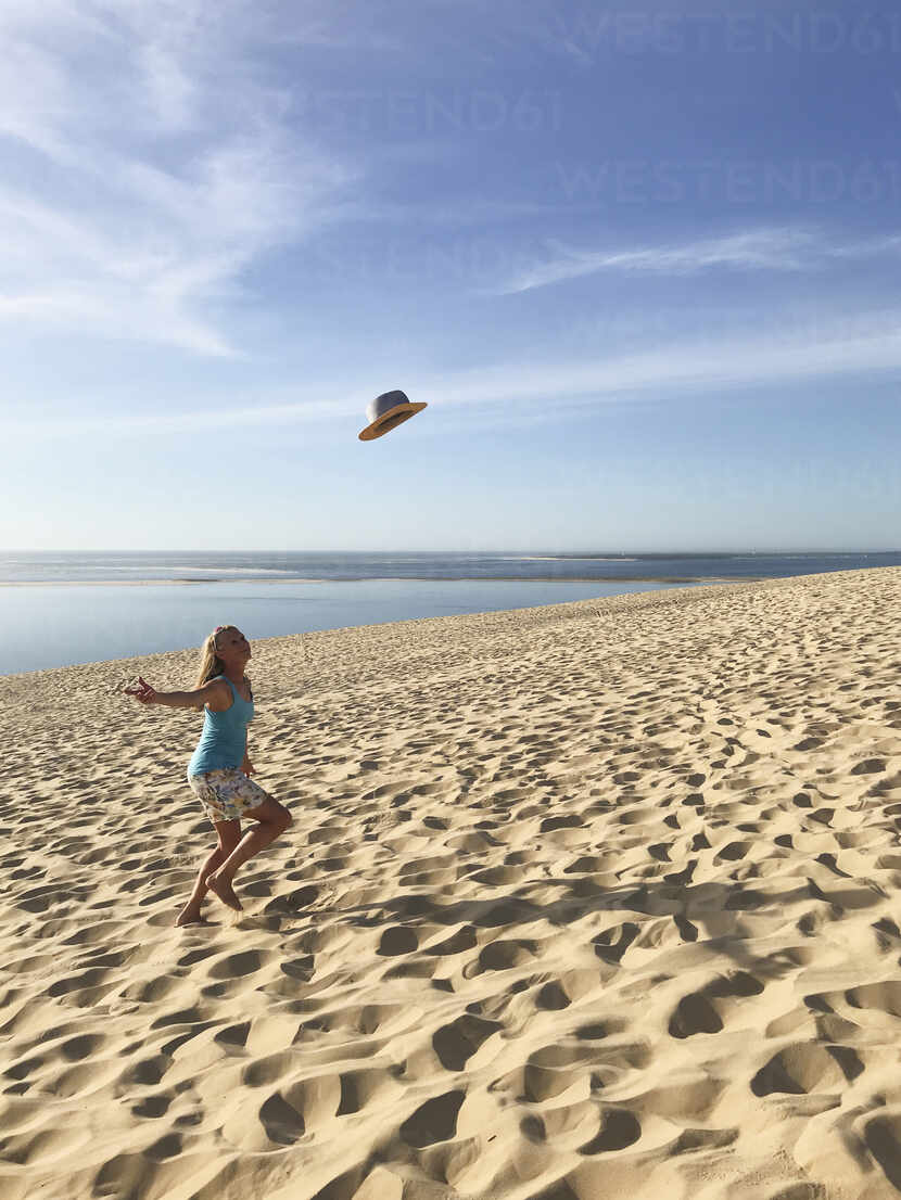 France Nouvelle Aquitaine Gironde Pyla Sur Mer Woman Throwing Straw Hat At Dune Du Pilat Gwf06335