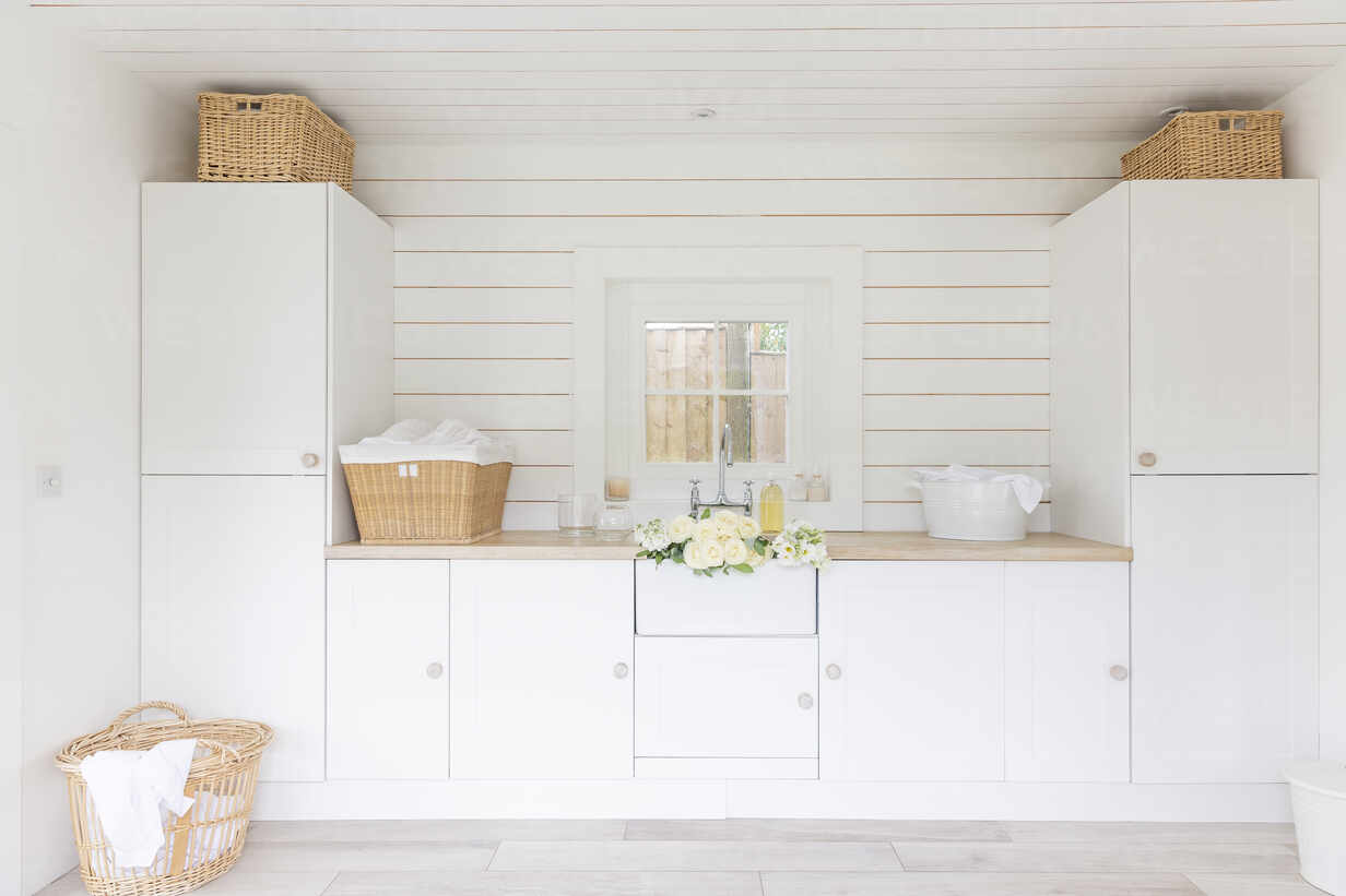 White Home Showcase Laundry Room With Cupboards And Baskets Stockphoto