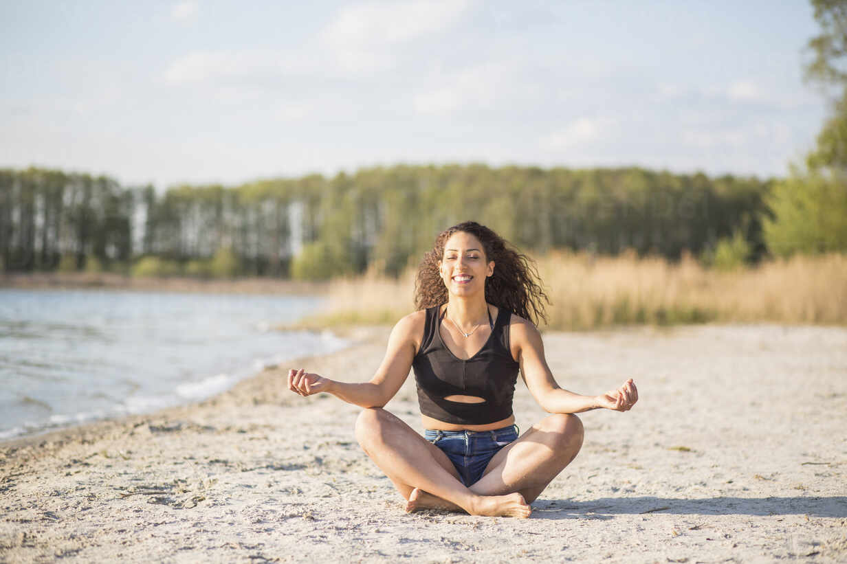 Portrait Of Young Woman Doing Yoga Exercise On The Beach Stockphoto