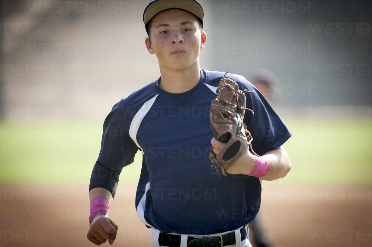 Close Up Of Teen Baseball Player In Blue Uniform Jogging Off The Filed Stockphoto